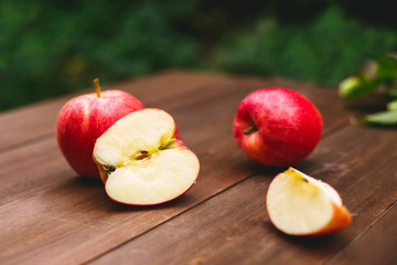 Naklejka na ściany i meble Juicy, freshly cut red apples on a wooden table