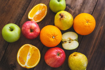 Different varieties of oranges, apples and pears on a wooden table