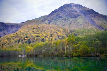 Natural landscape view of the autumn red-orange color forest with the mountain hill in Kamikochi,Matsumoto,Japan