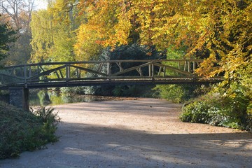 A bridge across a small river in a park