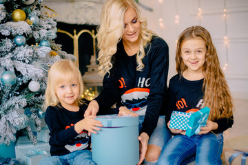young mother gives gifts to her little daughters