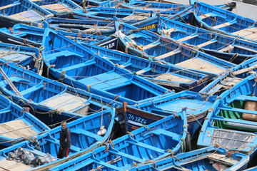 A lot of blue boats next to each other in the harbor.