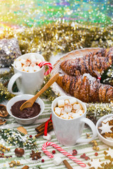 Christmas and New Year Background Breakfast with Croissants and Hot Cocoa with Marshmallows. Selective focus.
