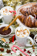 Christmas and New Year Background Breakfast with Croissants and Hot Cocoa with Marshmallows. Selective focus.