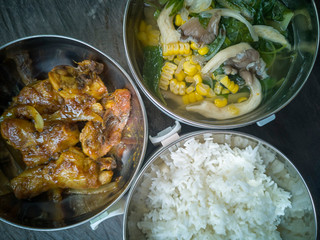 Selective focus the delicious meal consists of Chicken Oyster Sauce, White Rice and Vegetable Soup on the top of wooden table.