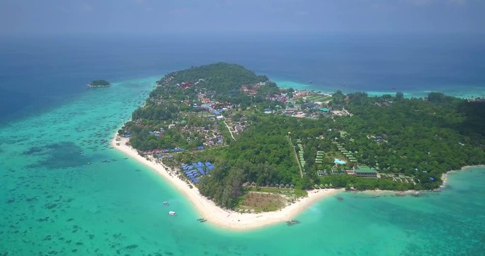 High altitude aerial view panning from tropical island Ko Lipe to the surrounding emerald green, crystal clear sea off Sunrise Beach on sunny day in Thailand. 4k 1.9:1 23.976fps