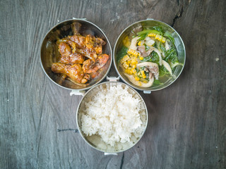 Selective focus the delicious meal consists of Chicken Oyster Sauce, White Rice and Vegetable Soup on the top of wooden table.