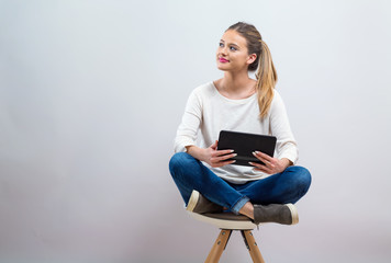 Young woman with a tablet computer on a gray background