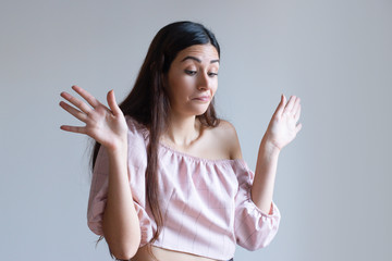 Pretty Caucasian girl showing raised palms in defense. Young female student denying reprimanding. Not me to blame concept