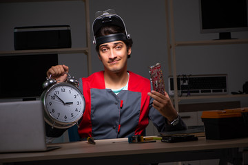 Young handsome repairman repairing computer 