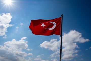 turkish flag against sun and blue sky 