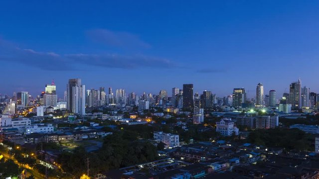 Panning LR panoramic Bangkok skyline time-lapse of sunrise transition from dark night city lights, dawn to blue sky day of downtown buildings along Sukhumvit Road. 16:9 4k at 30fps