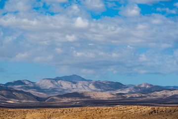 Cloudy blue sky over desert mountain landscape in California.