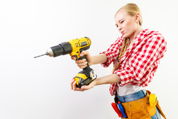 Woman using drill on wall