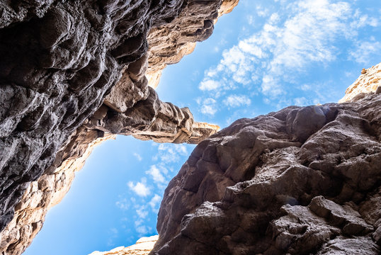 Looking up at cloudy blue skies from slot canyon in Anza-Borrgo State Park in California.