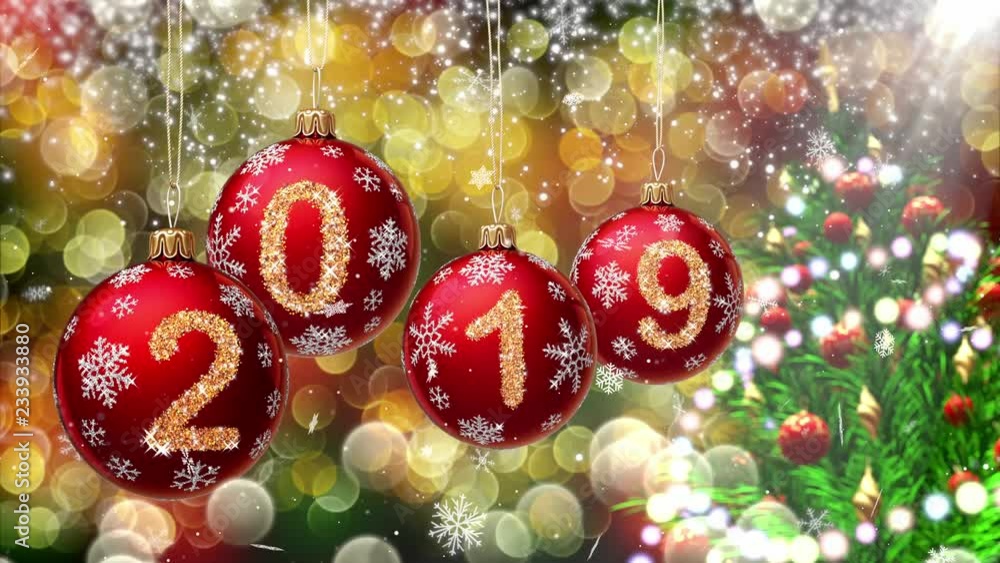 Wall mural red balls with numbers 2019 hanging on the background of a gold bokeh and a rotating christmas tree 