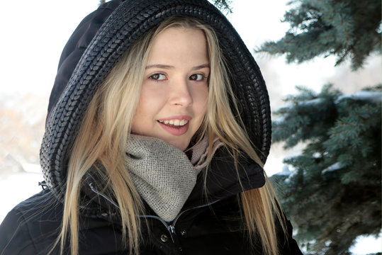 Девушка зимой возле сосны.