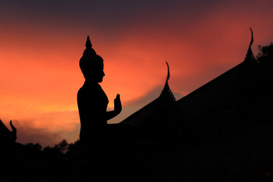 Silhouette Buddha statue in sunset