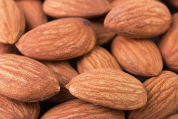 Almond nuts textured background closeup angle view. Organic food pattern.