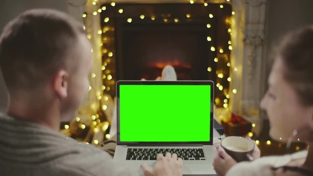 Young couple watching christmas movie on laptop