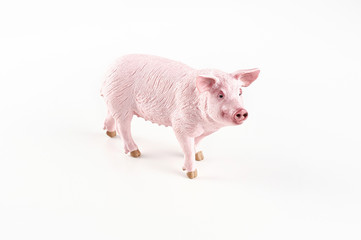 Plastic toy figurine of a pig on a white background. The symbol of the New Year in 2019