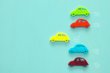 Abstract pastel colored wooden background with vibrant car shapes.