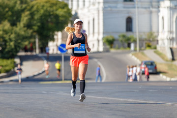 Young sporty woman running in marathon competition