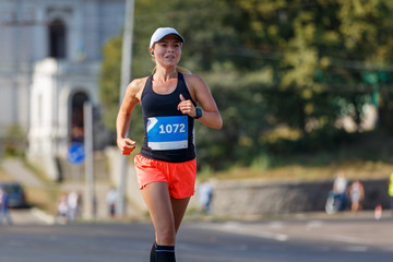 Young sporty woman running in marathon competition