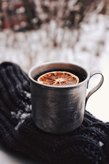 Hot tea with orange in vintage metal mug, winter mood