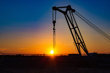 Obraz premium trailer crane at the construction site at sunset