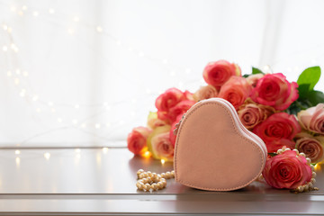 Rose fresh flowers bouquet on gray table by the window with heart gift box