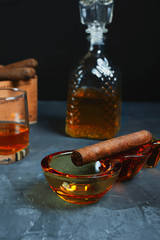 glass of whiskey and cigar on table
