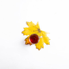 Autumn composition of yellow maple leaves on white background. Flat lay, top view, copy space. glass mug of tea and kettle