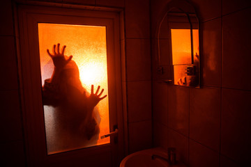 Horror silhouette of woman in window. Scary halloween concept Blurred silhouette of witch in...