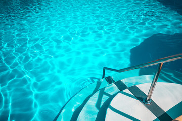 Obraz premium Swimming pool with white stairs in the hotel.