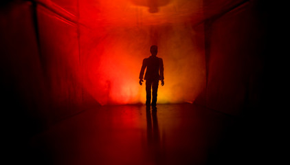 Creepy silhouette in the dark abandoned building. Horror about maniac concept or Dark corridor with cabinet doors and lights with silhouette of spooky horror person standing with different poses.