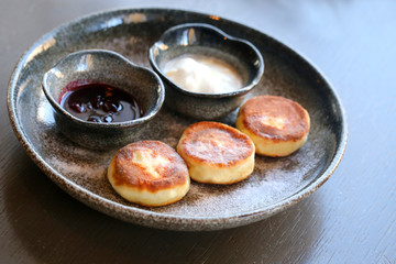 Macro photo of delicious bright cheese cakes with jam and sour c
