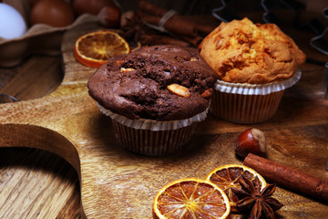Chocolate muffin and nut muffin, homemade bakery wooden background