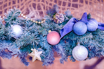 Christmas balls of silver and blue on a blurred background, decorated with a snow-covered branch of a Christmas tree .