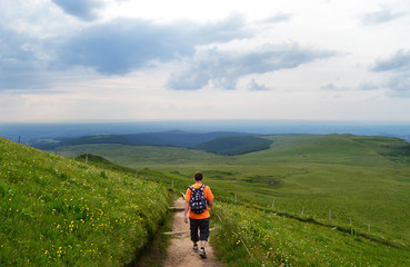 Obraz premium A hiker on a mountain trail in the Sancy massif in Auvergne