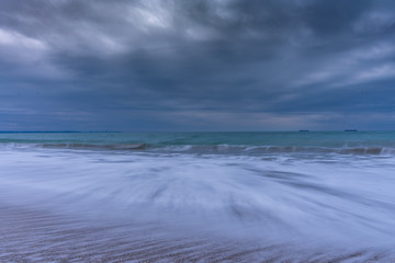 Winter morning on the beach. Cold Novemeber morning with big waves. Long exposure seascape. 