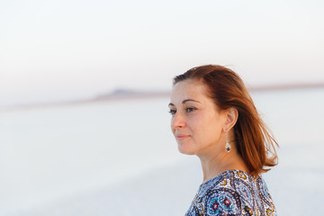 happy smiling girl in white hat enjoying sun, expanse of Bascunchak salt lake