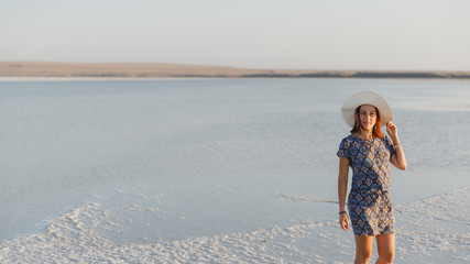 happy smiling girl in white hat enjoying sun, expanse of Bascunchak salt lake