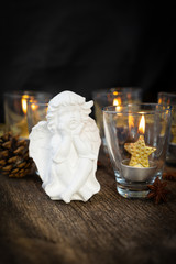 Fototapeta na wymiar Christmas white angel and glowing golden candles in glass