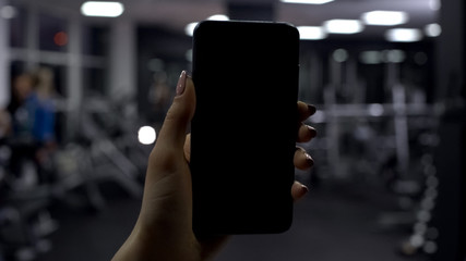 Woman checking amount of burned calories in smartphone application, black screen