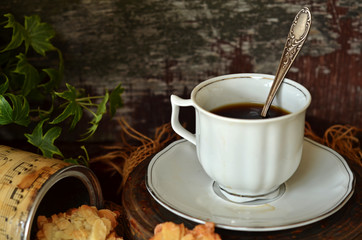 White cup of coffee on a white saucer on a dark background