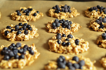 Oatmeal cookies with blueberries lying on baking paper