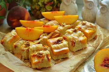 Pieces of cake with peaches lying on baking paper