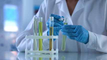 Scientist marking test tube with petroleum liquid, checking oil samples in lab