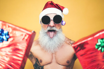 Tattooed fit santa claus doing crazy and giving christmas gifts - Trendy beard hipster senior...